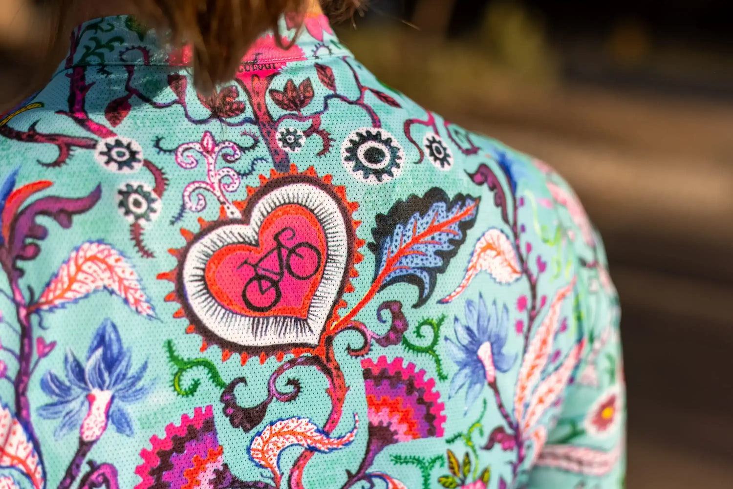 Colorful cycling jersey with heart and bike design, floral patterns on breathable fabric for women's bike wear