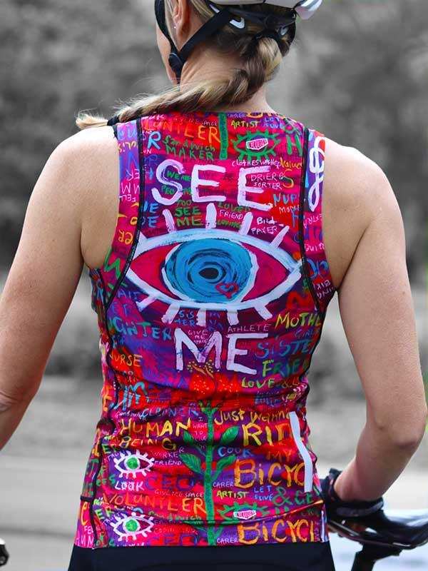 Woman wearing vibrant, graphic-print cycling jersey with eye design, ideal for road biking and athletic performance.