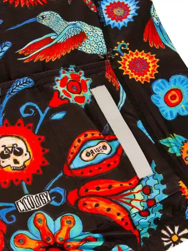 Vibrant cycling shorts with colorful floral and hummingbird print, reflective strip, and 'Cycology' logo
