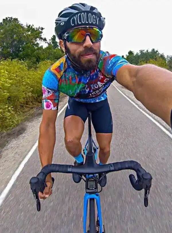 Cyclist in colorful cycling jersey and helmet riding road bike on scenic route