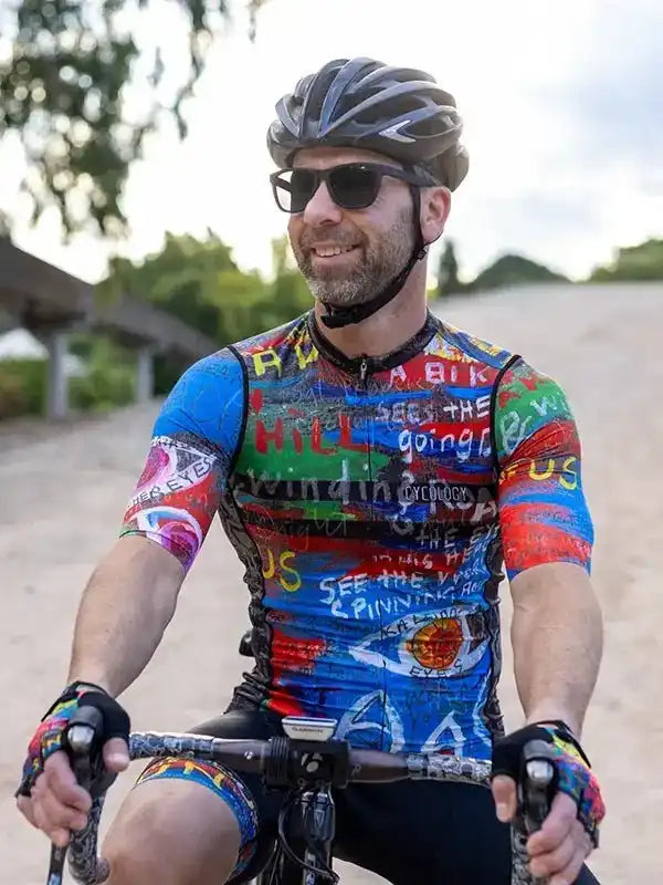 Man cycling in colorful graphic jersey and helmet, outdoor trail ride
