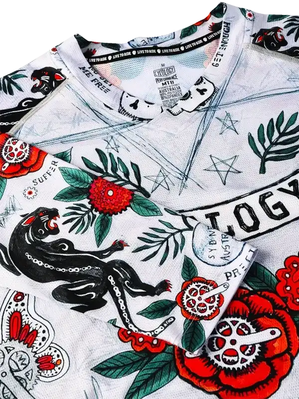 Men's cycling jersey with bold panther, red floral, and gear designs on white fabric