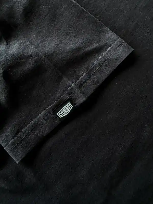Black cycling t-shirt sleeve with brand tag, showcasing durable fabric and clean stitching for active wear.