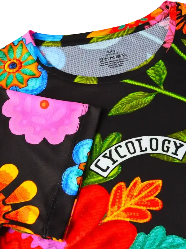 Vibrant floral cycling jersey with bold colors and 'Cycology' branding, perfect for women's cycling wear.