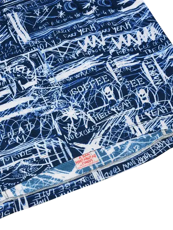Blue cycling jersey with white graffiti-style graphics and bold text, featuring edgy design details