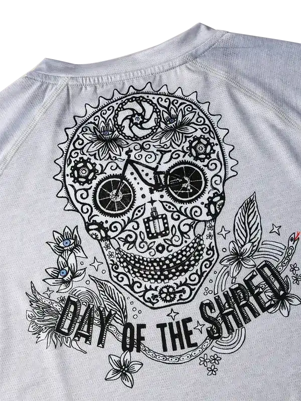 Men's cycling jersey with sugar skull design, 'Day of the Shred' text, floral and bike gear graphics