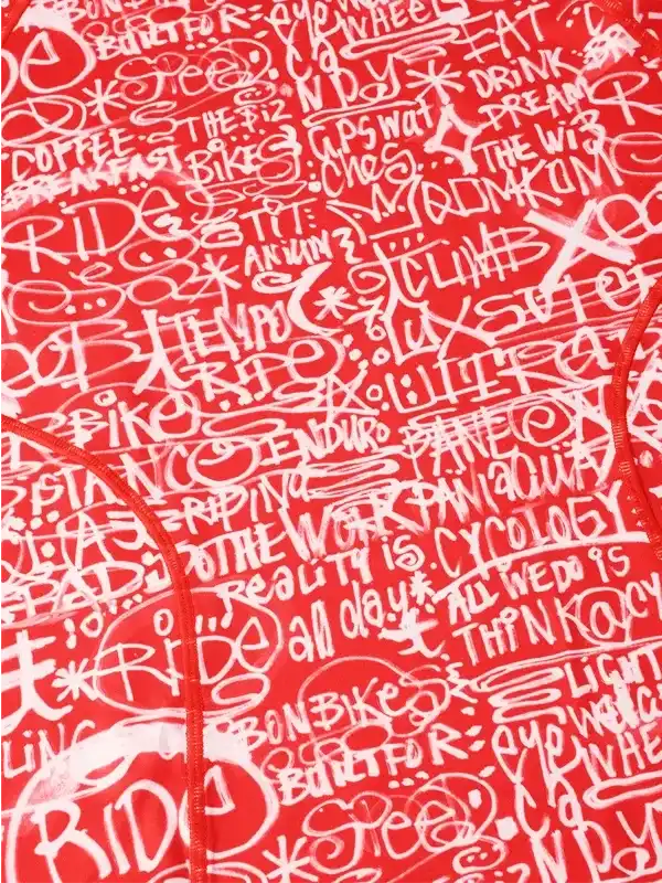 Red cycling jersey with white graffiti-style cycling phrases and slogans