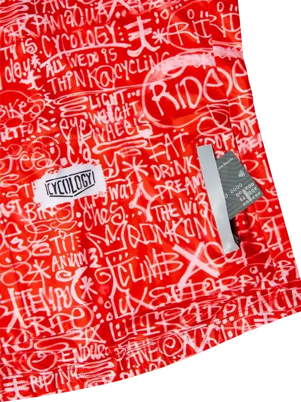 Red cycling jersey with white graffiti-style text and Cycology brand tag, featuring bold ride-themed graphics.