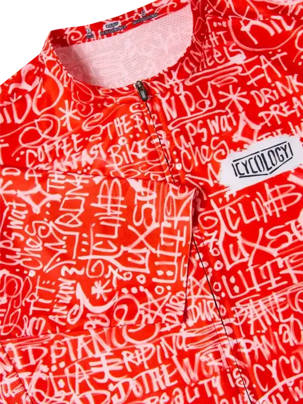 Red cycling jersey with white graffiti-style text, featuring 'CYCOLOGY' logo and zippered front.