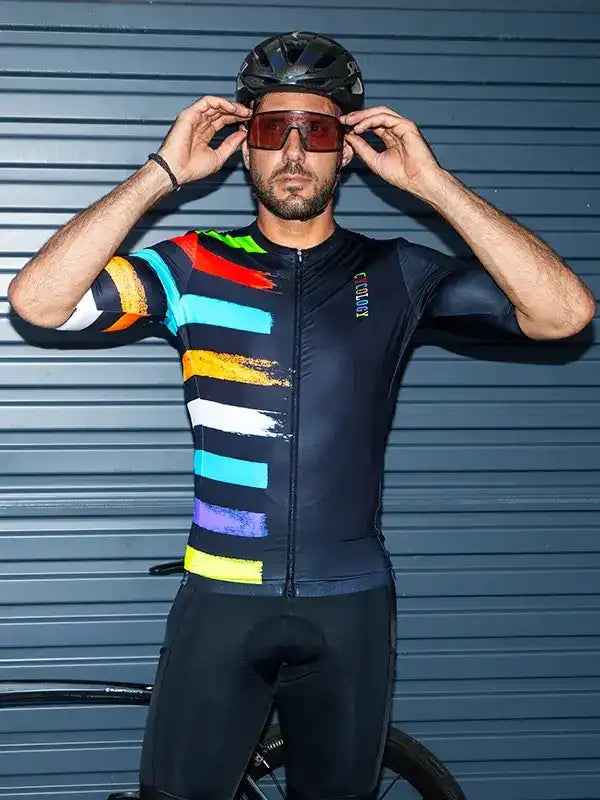 Man in colorful striped cycling jersey adjusting sunglasses, wearing helmet and bib shorts