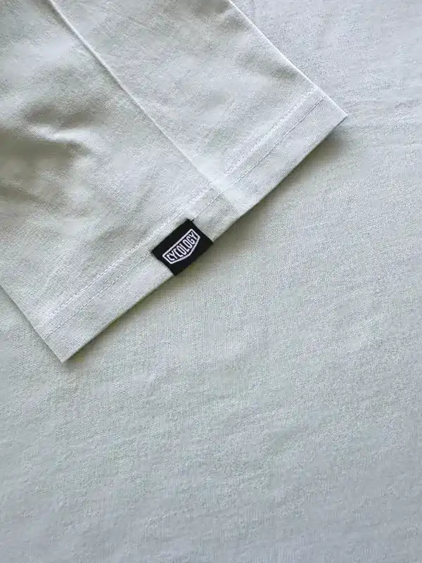 Light gray cycling jersey sleeve with black Cycology tag, showcasing quality fabric and stitching detail.