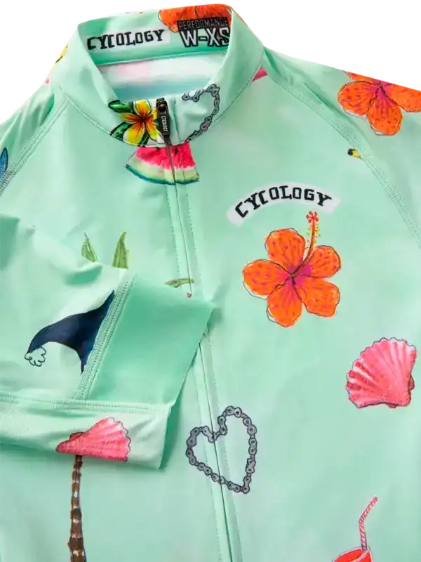 Mint green women's cycling jersey with tropical hibiscus, seashell, and palm tree print, featuring full zip and performance fabric.