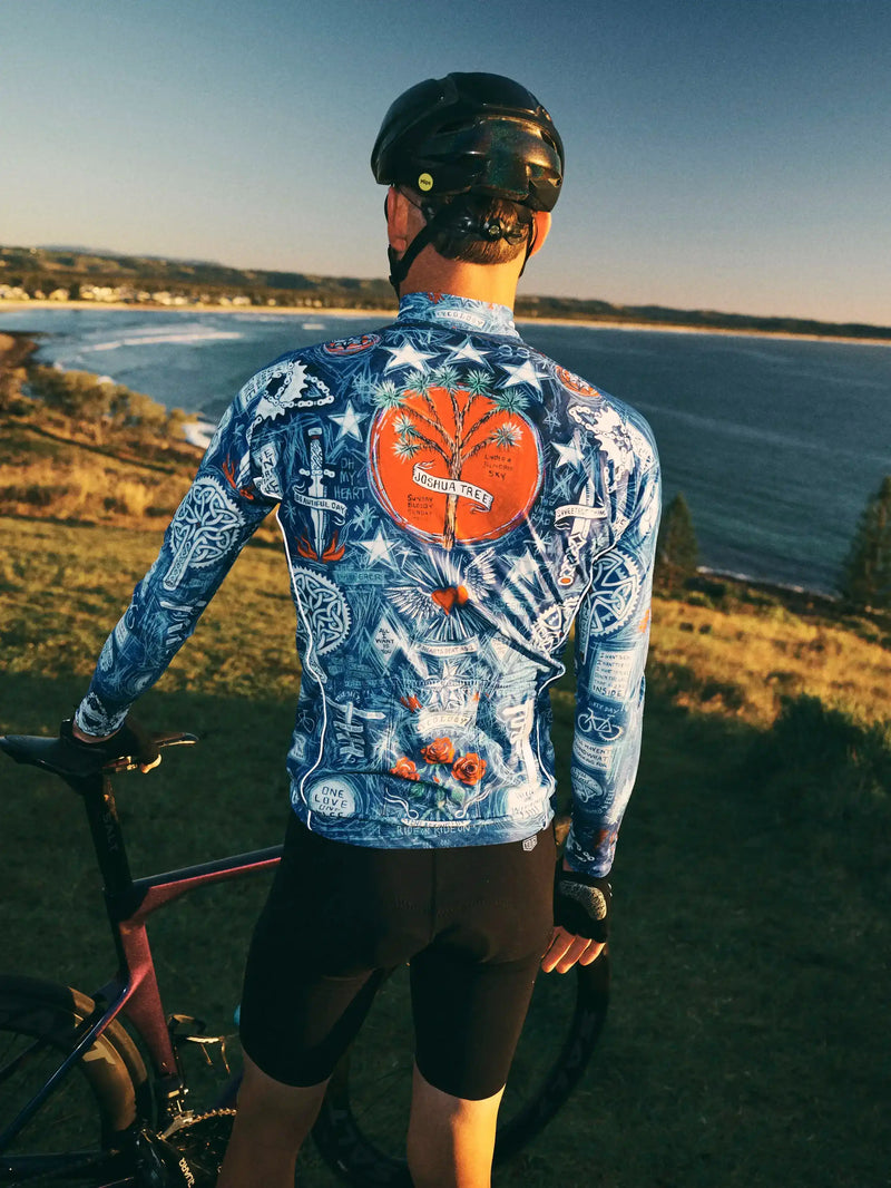 Men's long sleeve cycling jersey with Joshua Tree design, worn by cyclist overlooking ocean at sunset