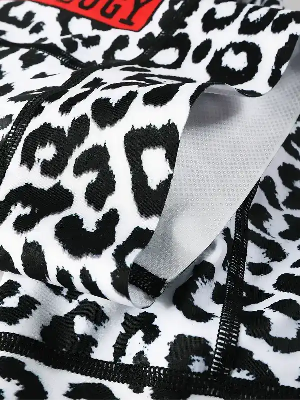 Black and white leopard print cycling shorts with mesh lining and red logo detail