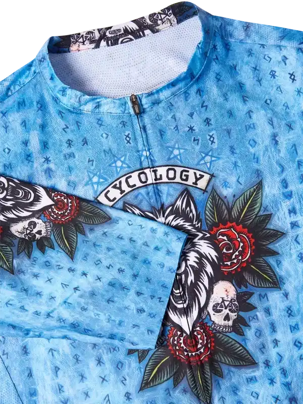 Blue cycling jersey with skull, rose, and wolf tattoo design, featuring 'CYCOLOGY' logo and patterned fabric.