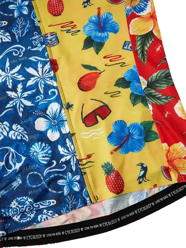 Vibrant tropical print cycling shorts with hibiscus, pineapple, and beach motifs in blue, yellow, red