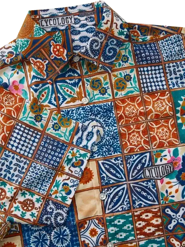 Colorful patchwork cycling shirt with floral and geometric patterns, featuring button front and brand tag