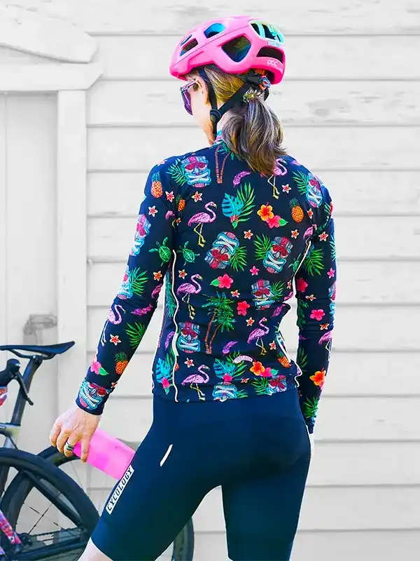 Woman in tropical flamingo print cycling jersey and pink helmet, ready for a ride