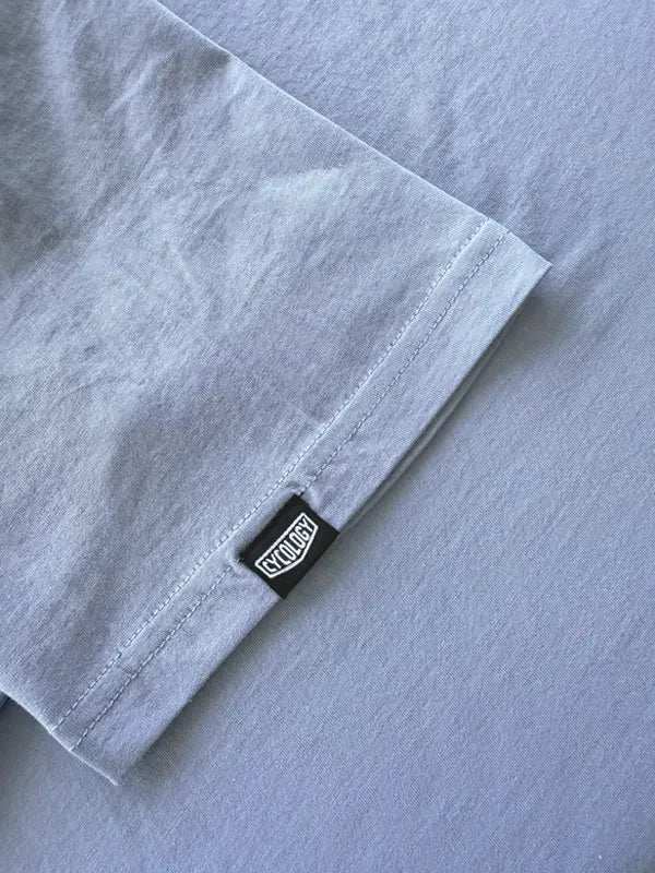 Light gray cycling t-shirt sleeve with black CYCLOGY tag, soft fabric detail for men's and women's bike wear