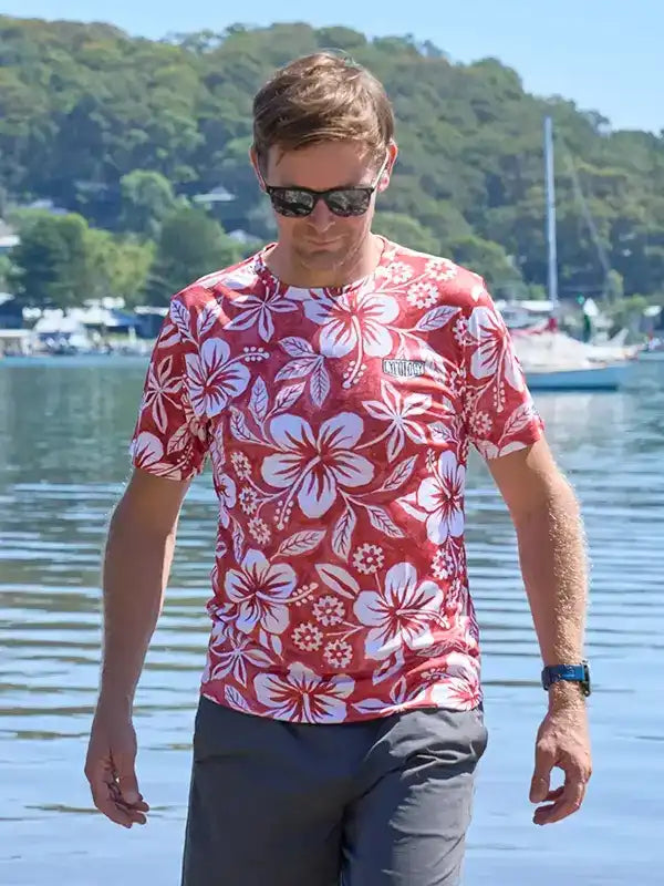 Man wearing red floral cycling jersey by water, stylish active wear for outdoor adventures