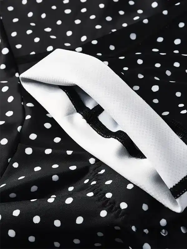 Black and white polka dot cycling jersey with white collar and black trim detail