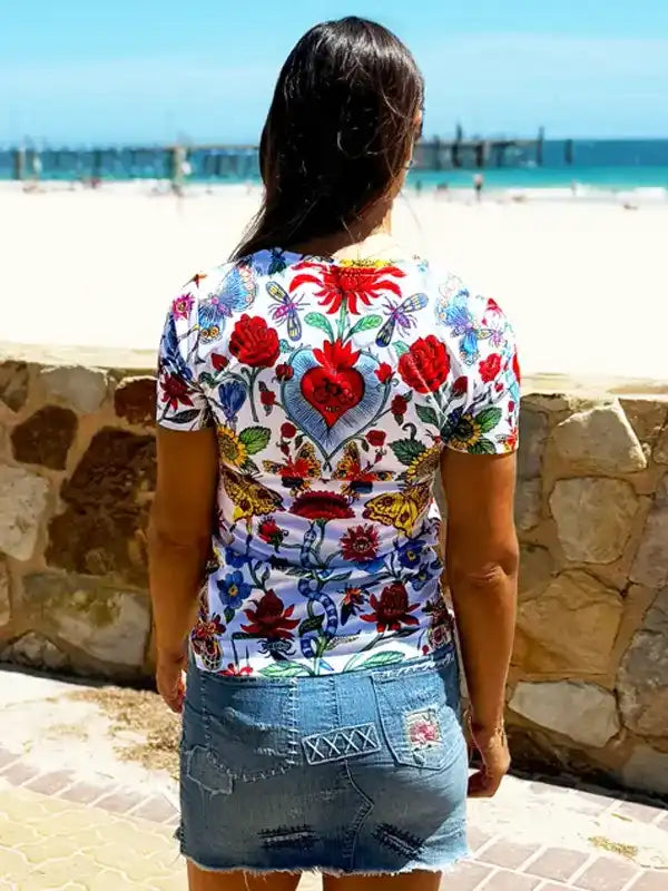 Woman wearing colorful floral cycling jersey with heart design, beach background