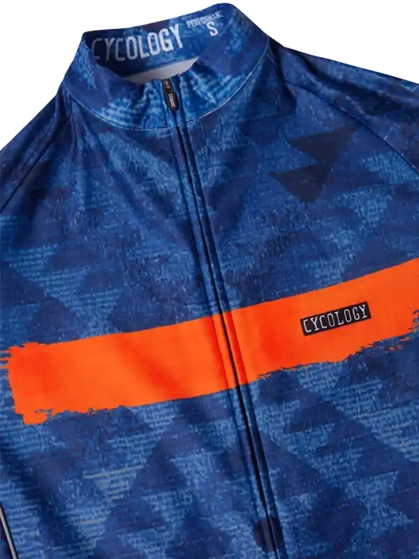 Blue cycling jersey with orange stripe and geometric pattern, featuring full zip and performance fabric.