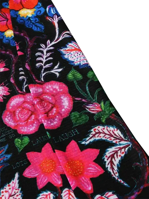 Vibrant floral cycling jersey with pink roses, green leaves, and 'LAUGH' text on black fabric