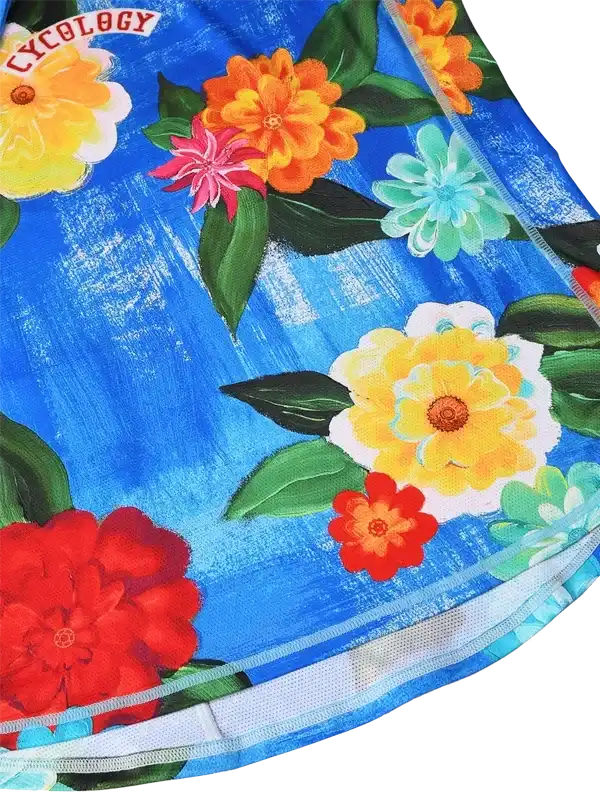 Vibrant floral cycling jersey with bold blue background and colorful blooms, featuring Cycology logo