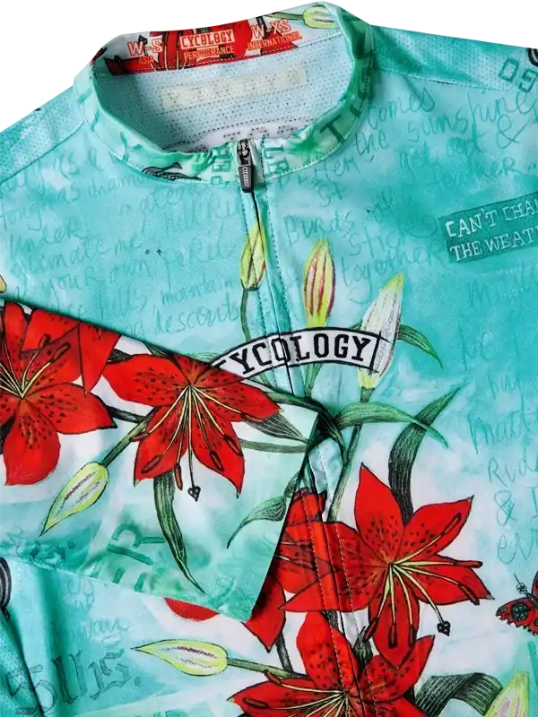 Women's cycling jersey with red lily print, breathable fabric, and zippered front for performance rides