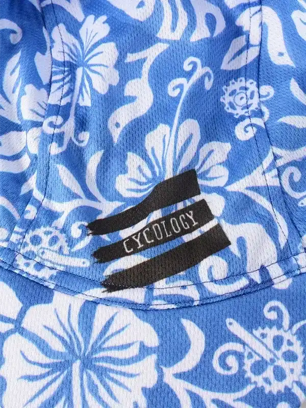 Blue cycling jersey with white floral pattern and Cycology logo tag