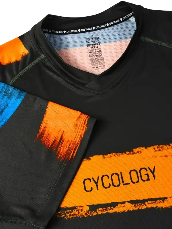 Men's black cycling jersey with bold orange and blue graphics, featuring 'CYCOLOGY' text and performance fabric details.
