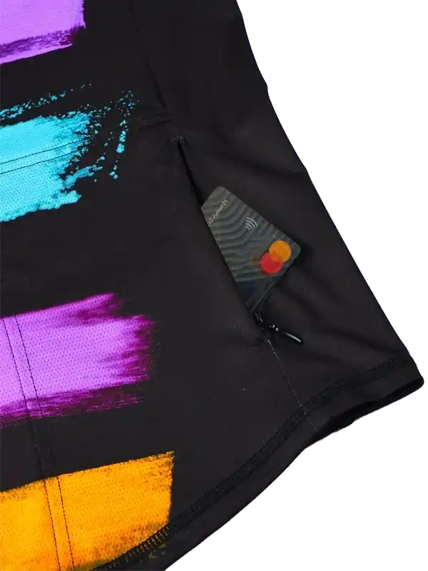 Black cycling shorts with vibrant purple, blue, and orange abstract print, featuring rear zip pocket holding card