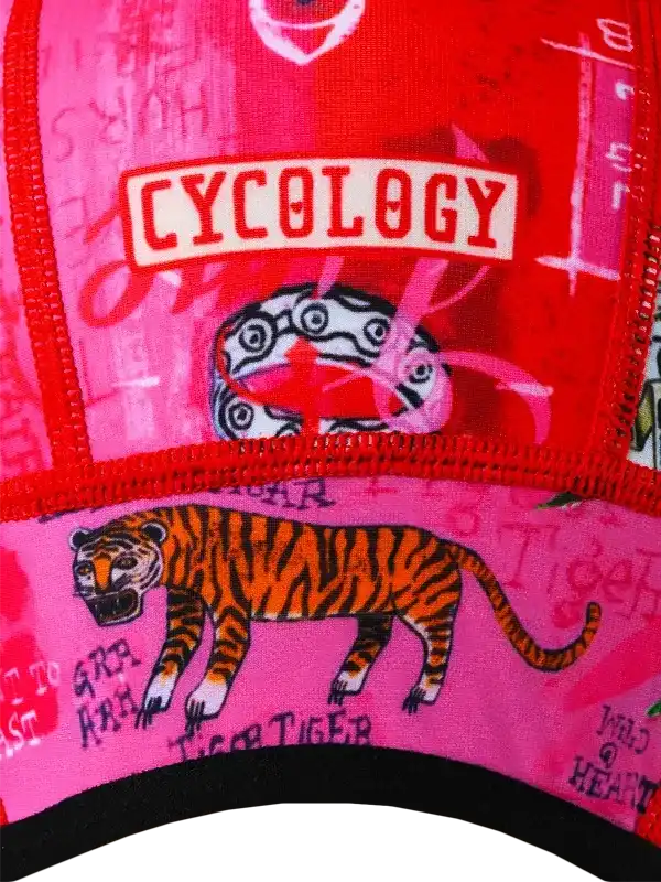 Vibrant red and pink cycling cap with bold tiger graphic and 'CYCOLOGY' logo, perfect for bike rides.