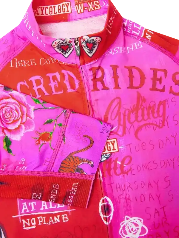 Vibrant pink and red women's cycling jersey with rose, tiger, and heart graphics, bold text design