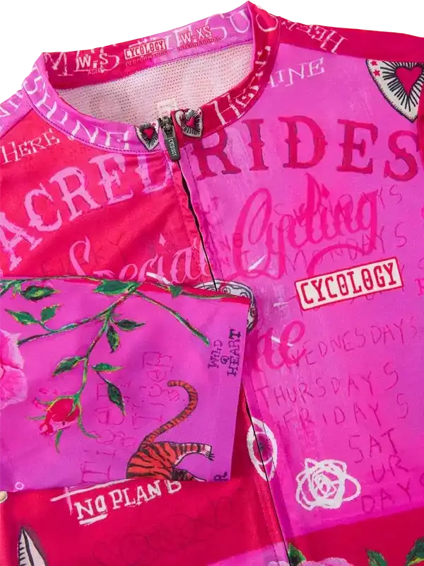 Pink cycling jersey with floral and tiger print, bold text designs for women's cycling apparel