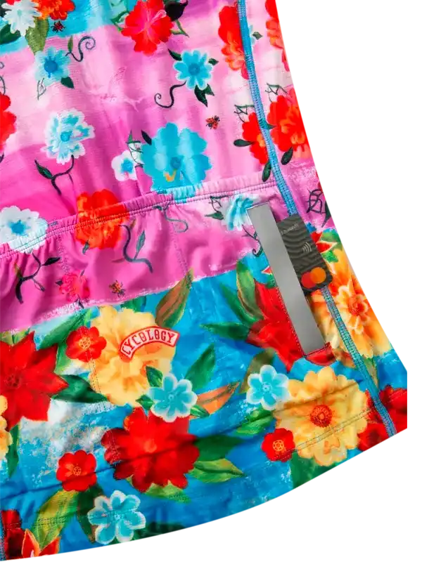 Vibrant floral cycling shorts with pink and blue hues, featuring reflective strip and brand patch