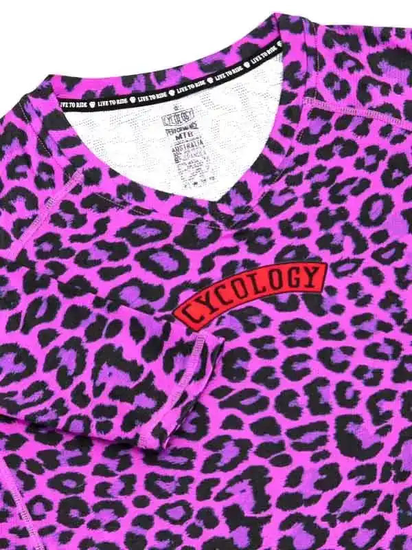 Vibrant pink leopard print cycling jersey with red Cycology logo, ideal for women's cycling apparel.