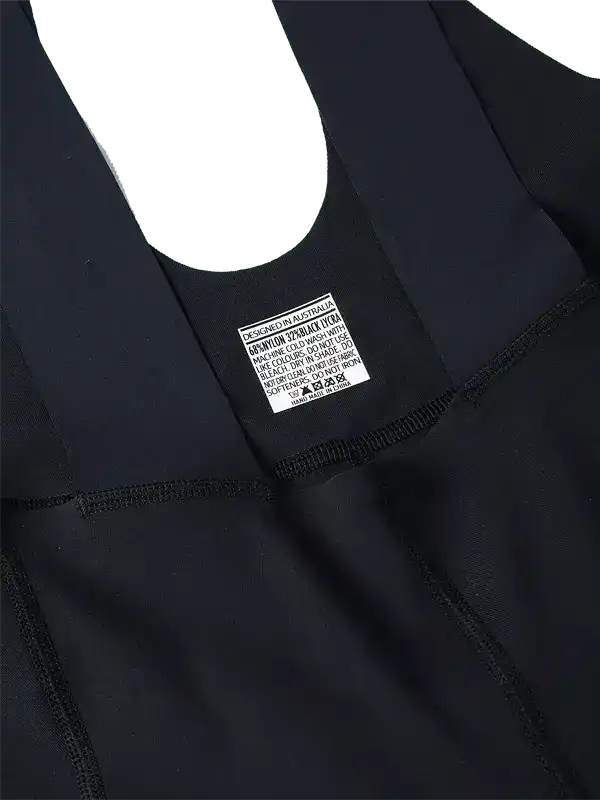 Black cycling jersey with care label, designed in Australia, featuring high-quality fabric and seamless stitching.