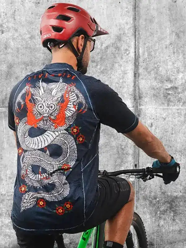 Men's cycling jersey with dragon graphic, worn by cyclist in red helmet, urban concrete setting