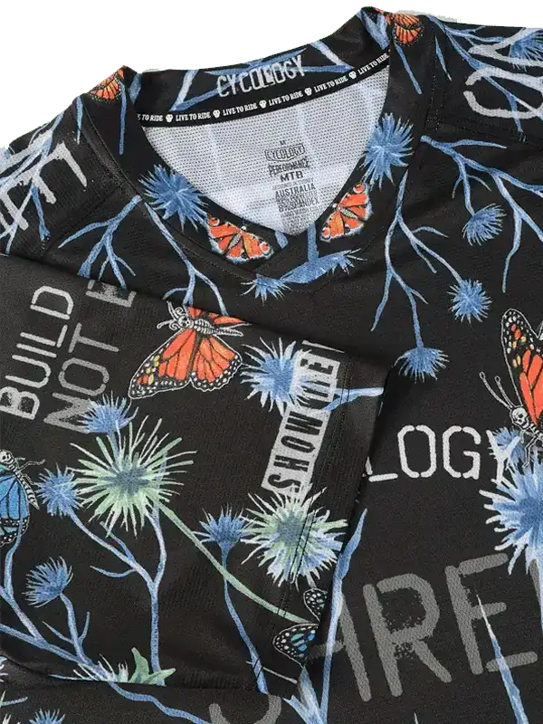 Black cycling jersey with butterfly and thistle print, featuring bold text design for men's and women's rides