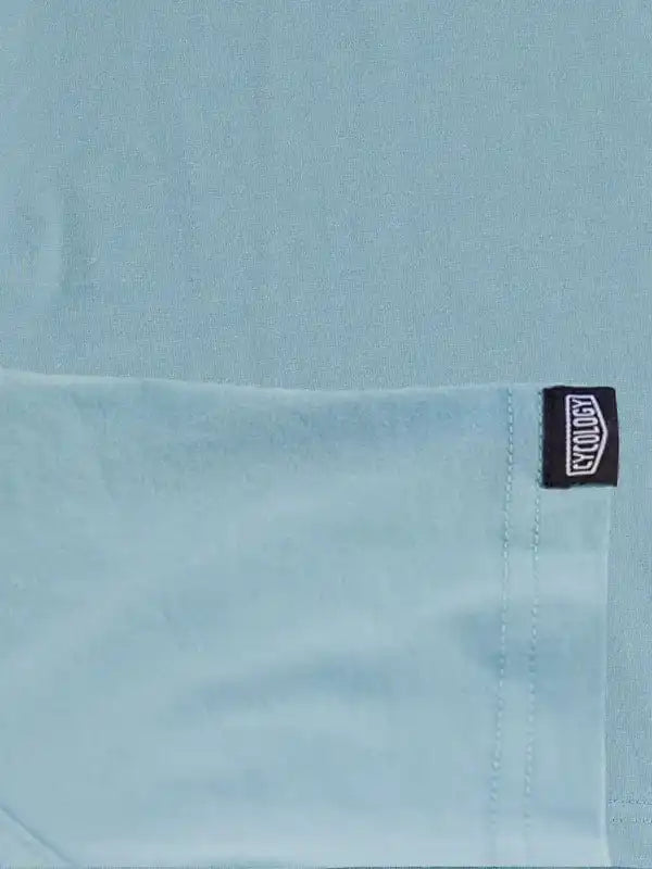 Light blue cycling jersey with black brand tag, high-quality fabric detail