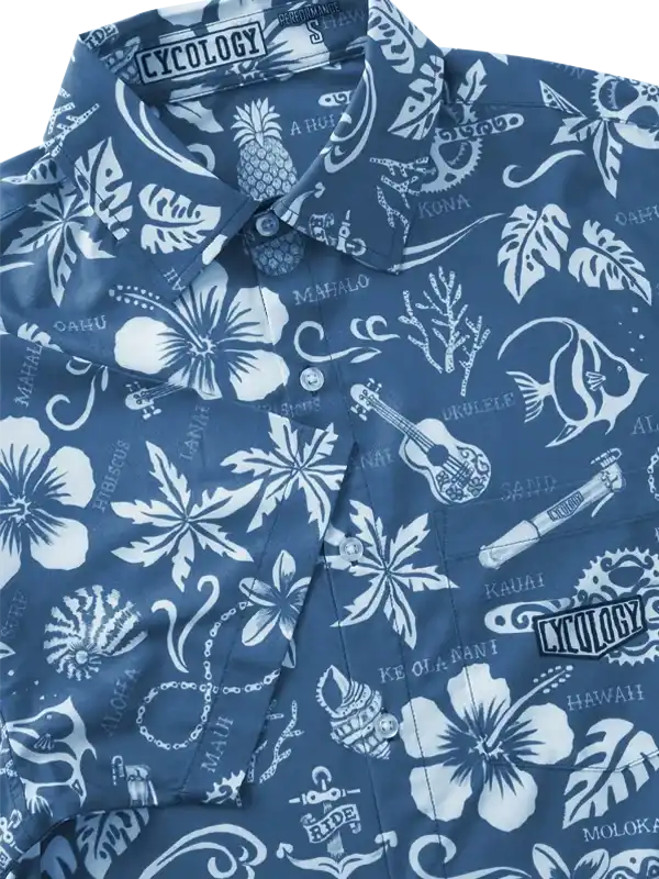 Blue Hawaiian-style cycling shirt with white floral, pineapple, and ukulele print, featuring 'Cycology' branding