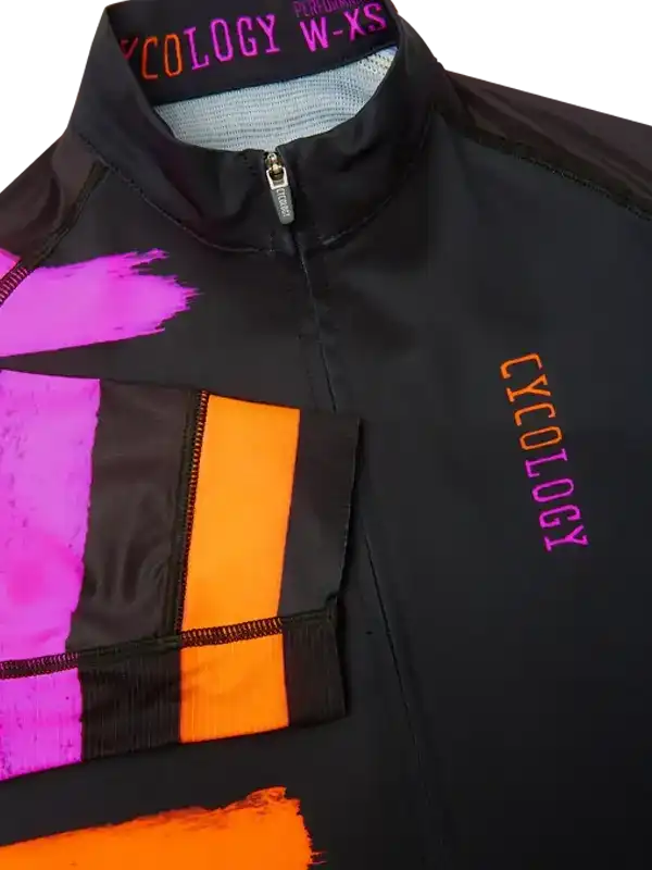 Black women's cycling jersey with bold pink and orange graphic design, zippered front, and brand logo