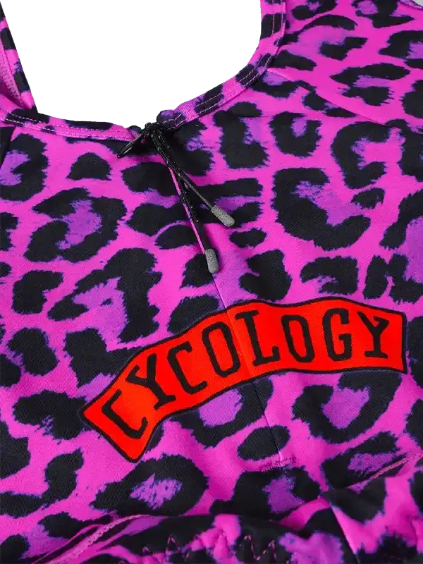 Vibrant pink leopard print cycling top with bold red Cycology logo, featuring drawstring neckline for adjustable fit.
