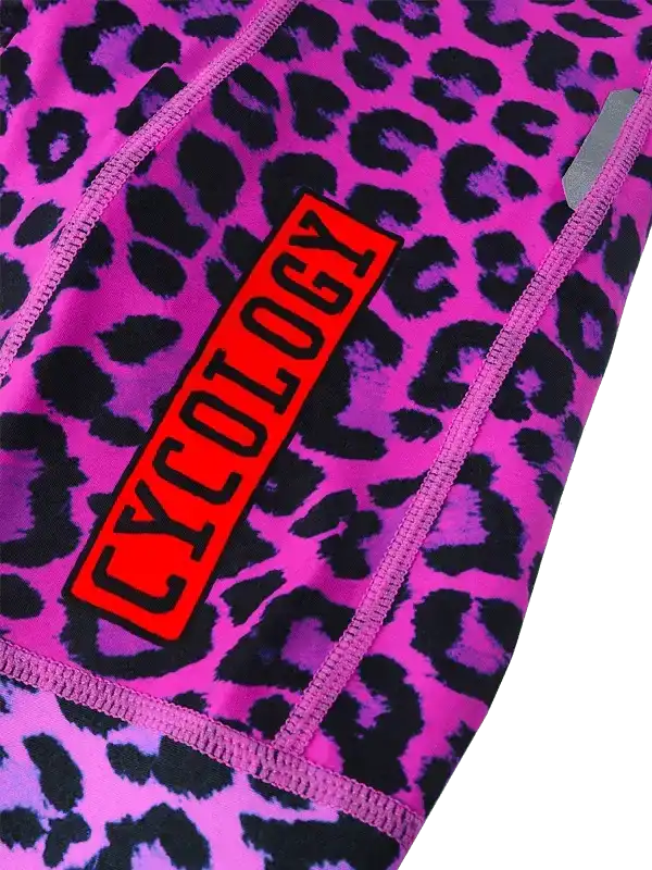 Pink leopard print cycling shorts with bold red Cycology logo, high-quality athletic wear for women