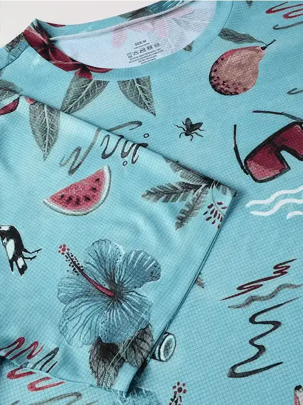 Men's tropical print cycling jersey with hibiscus, watermelon, and fruit design on light blue fabric