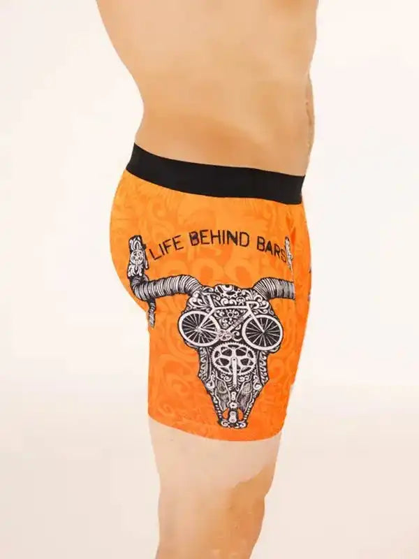 Orange men's cycling shorts with bull skull and bike wheel design, black waistband