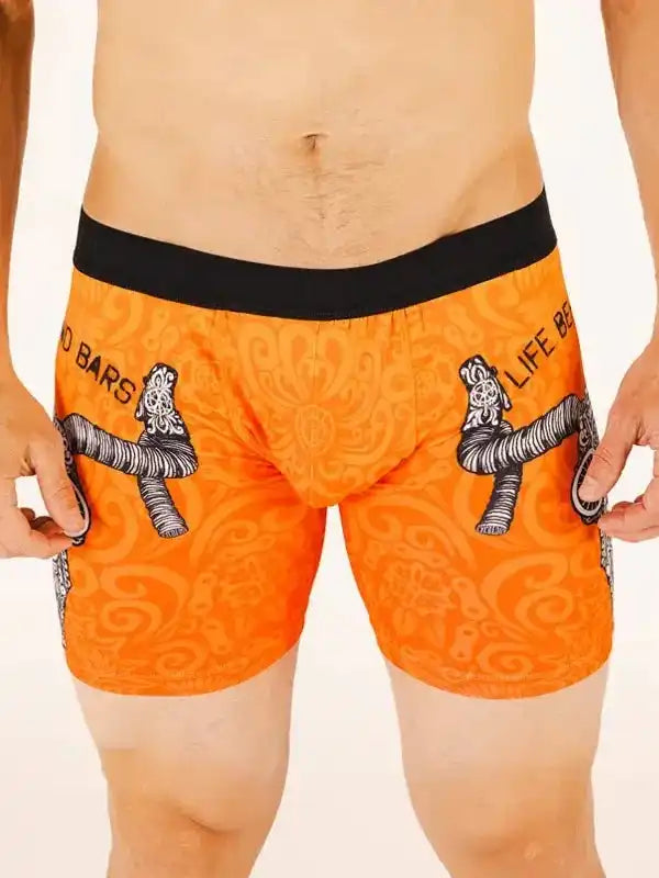 Orange men's cycling shorts with black waistband and graphic bike handlebar design