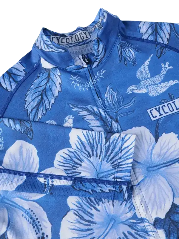 Blue floral cycling jersey with hibiscus print and bird design, featuring breathable fabric and zippered collar